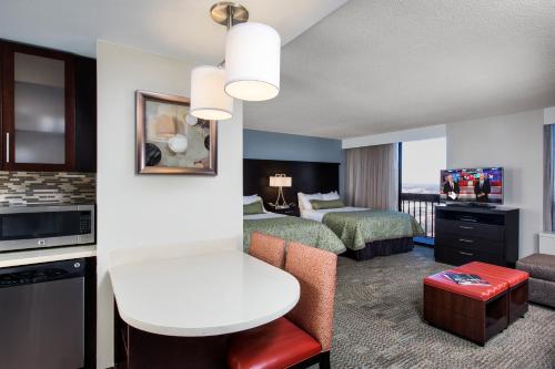 a hotel room with two beds and a living room at Staybridge Suites Atlanta - Midtown by IHG in Atlanta