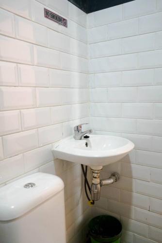 a white bathroom with a sink and a toilet at Puspiptek Residence Syariah in Curug 3