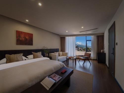 a bedroom with a large bed and a living room at Lijiang Ancient City Hitone Rizhao Jinshan Sky Garden Snow Mountain Viewing Resort in Lijiang