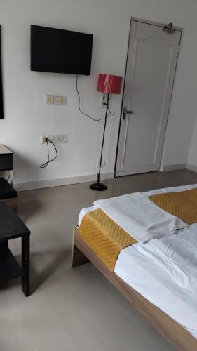 a bedroom with a bed and a flat screen tv at Soooper Hotel 2 in Jāmb