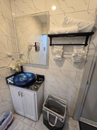 a bathroom with a blue sink and a mirror at El Rincón - El Jardín in Tunapuna