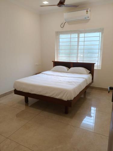 a large bed in a room with a window at Jayanthi Mahal in Tiruchirappalli
