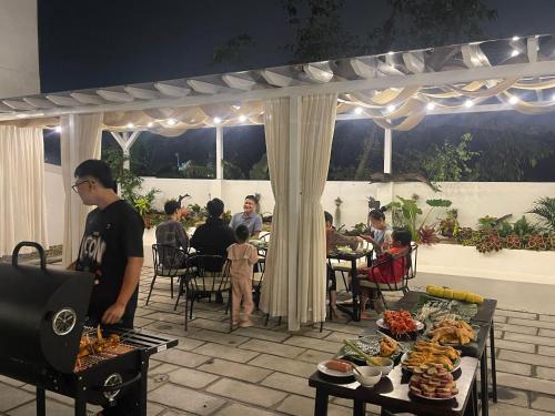 a man standing on a patio with a table of food at Sol Flow Retreat in Nguyên Ngoại