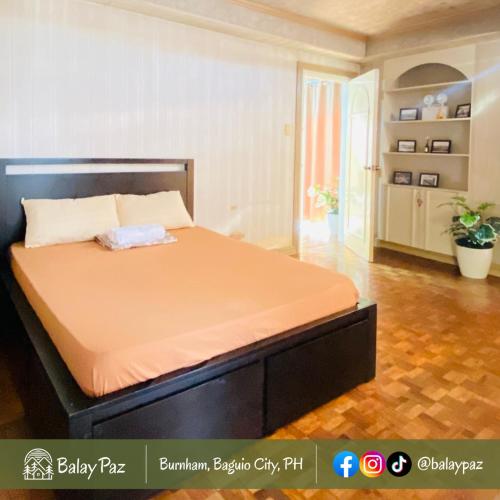 ein Bett in einem Schlafzimmer mit einer orangefarbenen Matratze in der Unterkunft City View 2BR Home in Burnham - Dalisay Unit by Balay Paz in Baguio City