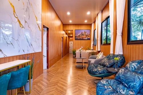 a living room with wooden walls and blue chairs at The View Villa in Chiang Dao