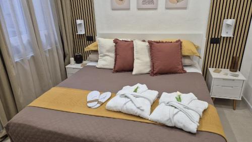 a bed with towels and flip flops on it at Ti porto al mare - Luxury & Relax in Siracusa