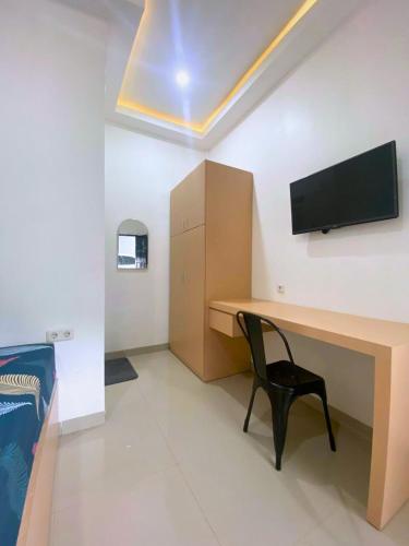 a room with a desk with a tv and a chair at Casa Bella Homestay in Palembang