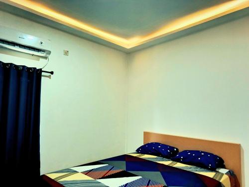 a bedroom with a bed with blue pillows at Casa Bella Homestay in Palembang