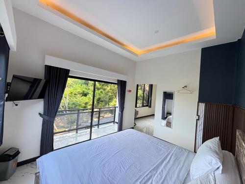 ラブハン・バジョにあるHostel Labuan ORAのベッドと大きな窓のある寝室