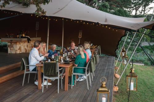 a group of people sitting at a table under a tent at The Alexander Estate in Noordhoek