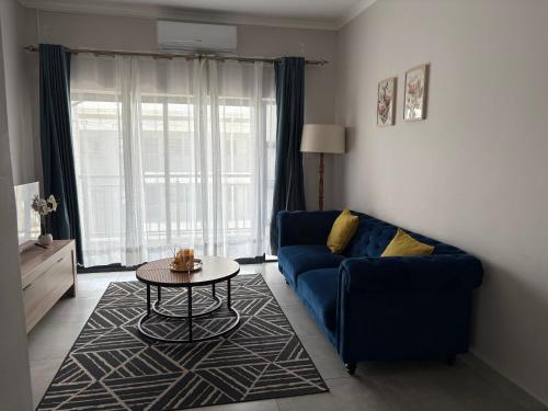 a living room with a blue couch and a table at Haven & Beyond in Gaborone