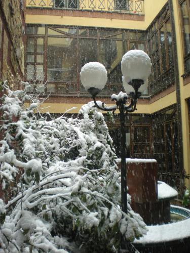 a street light covered in snow next to a building at Hotel Le Mura e Residence in Città di Castello