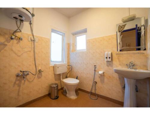 um banheiro com chuveiro, vaso sanitário e pia em goSTOPS Srinagar em Srinagar