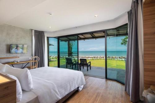 a bedroom with a bed and a view of the ocean at i Tara Private in Ban Laem Phak Bia (1)