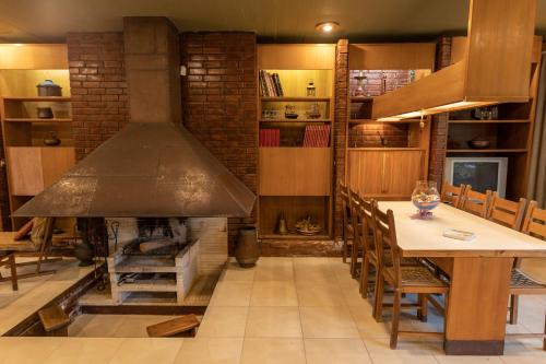 a kitchen with a stove and a table and a fireplace at Retro House in Rafina