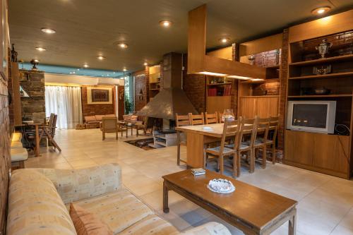 a living room with a couch and a table and a tv at Retro House in Rafina