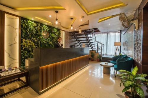 a man standing behind a counter in a lobby at The Avenue Hotel & Banquet Near Bhopal Junction in Bhopal