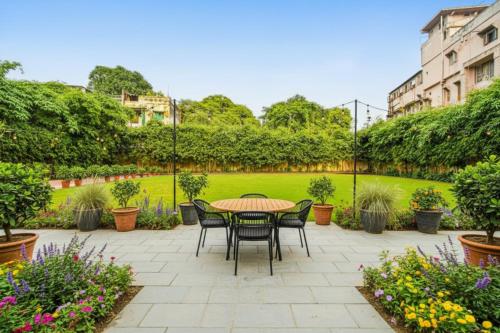 a patio with a table and chairs in a garden at The Avenue Hotel & Banquet Near Bhopal Junction in Bhopal