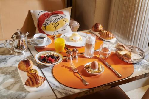 una mesa de desayuno con pasteles y platos de comida naranja en Luxury Collection Hotel, en Sevan