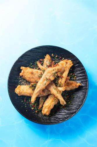 a black plate with french fries on a blue at Kempinski Hotel Hangzhou in Hangzhou