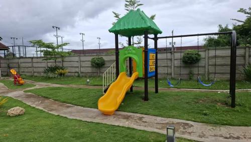 a playground with a slide in a yard at Azure Edge in Dauis