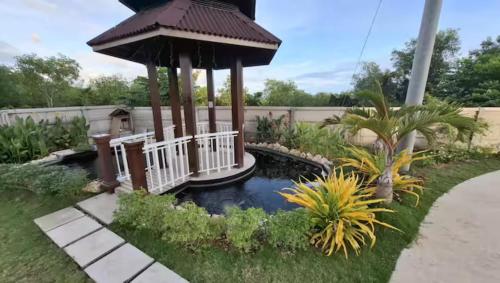 a garden with a pond and a gazebo at Azure Edge in Dauis