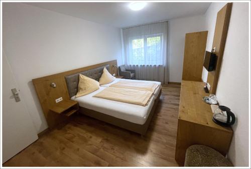 a bedroom with a bed and a television in it at Herr Berge in Fritzlar