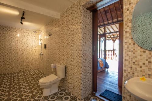 a bathroom with a toilet and a tub and a sink at Pondok Tegal Tunon Villa Ubud Bali in Ubud