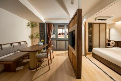 a bedroom with a bed and a desk and a television at Lune Boutique Apartment Da Nang in Da Nang