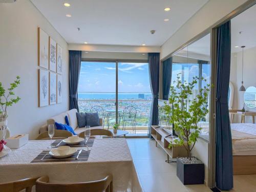 a living room with a dining table and a view of the ocean at The Song Apartment 5 Stars Vung Tau - Căn Hộ Du Lịch 5 Sao Cạnh Biển - DUMIN HOMESTAY in Vung Tau