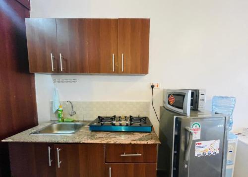 a small kitchen with a sink and a microwave at Habun Homes in Ruaka