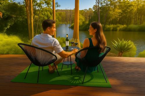 a man and woman sitting at a table with wine glasses at Zen on the River Lux 3BR with Japanese Deep Bath Walk to Down Town in Margaret River Town