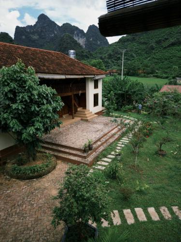 ein kleines Haus mit Bergen im Hintergrund in der Unterkunft Là Nhà Homestay in Hữu Lũng