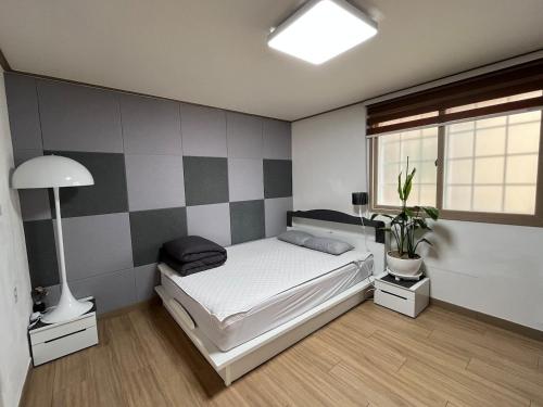 a bedroom with a bed and a potted plant at Like a local resident near a major tourist attraction in Gyeongju, can store luggage in Gyeongju
