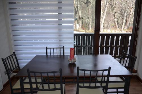 a dining room table with chairs and a window at Departamento Termas de Chillan in Nevados de Chillan