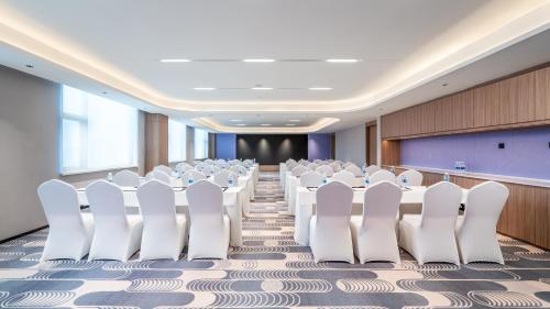 een conferentiezaal met witte stoelen en een podium bij Holiday Inn Express Ziyang City Center by IHG in Ziyang