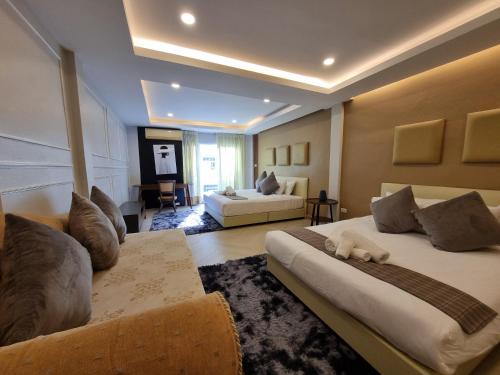 a bedroom with two beds and a living room at RB9 Oliver's House in Kaset in Ban Yang