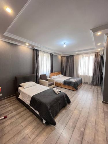 une chambre d'hôtel avec deux lits et un canapé dans l'établissement Riverside Cotagge, à Poti