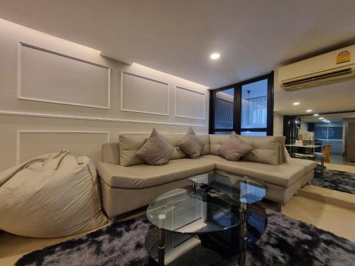a living room with a couch and a glass table at RB9 Oliver's House in Kaset in Ban Yang