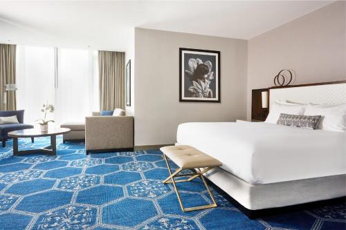 Un dormitorio con una gran cama blanca y una alfombra azul en Luxury Collection Hotel, en Sevan