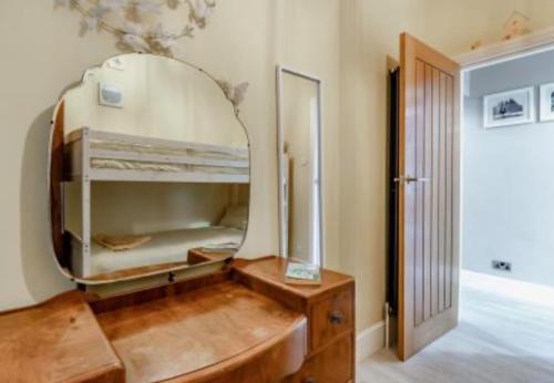 een kamer met een spiegel en een houten dressoir bij Ocean view in Swanage