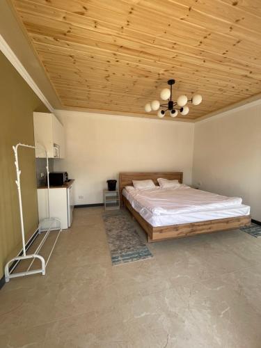 a bedroom with a bed and a wooden ceiling at Guest house Amirhan in Bokonbayevo