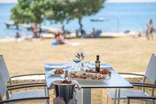 einen Tisch mit einem Teller Essen am Strand in der Unterkunft Mobilehomes in Rovinj - Istrien 50060 in Rovinj