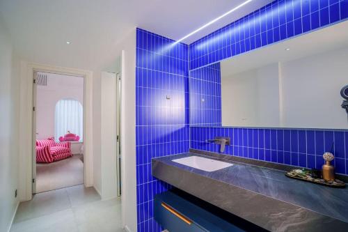 a blue tiled bathroom with a sink and a mirror at 4 RMs city APT, Easy to go all attractions in Zhangjiajie