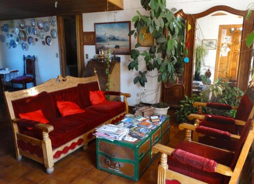 a living room with a red couch and a table at Posada del Buscador in El Bolsón