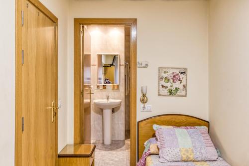 a bathroom with a sink and a bed and a sink at Hostal la Barretina in Figueres