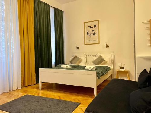 1 dormitorio con cama blanca y cortinas verdes en Studio Old Town with Jacuzzi and View, en Bucarest