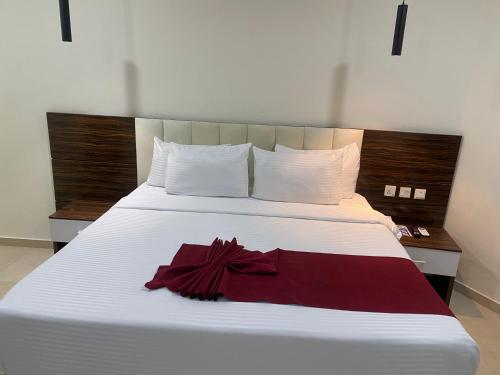 a white bed with a red dress on it at Chateux de atlantique Hotel in Lagos