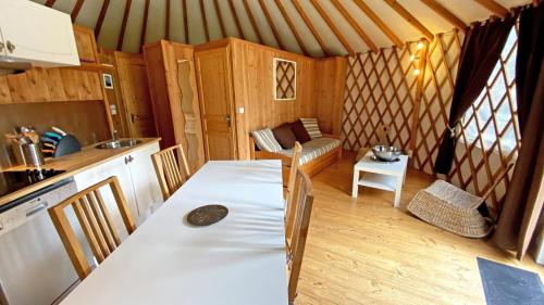 a room with a kitchen and a table in a yurt at Gîte Les yourtes de Saint Mathieu N°1 in Saint-Mathieu