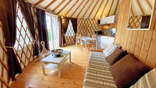 a room with a couch and a table in a yurt at Gîte Les yourtes de Saint Mathieu N°1 in Saint-Mathieu